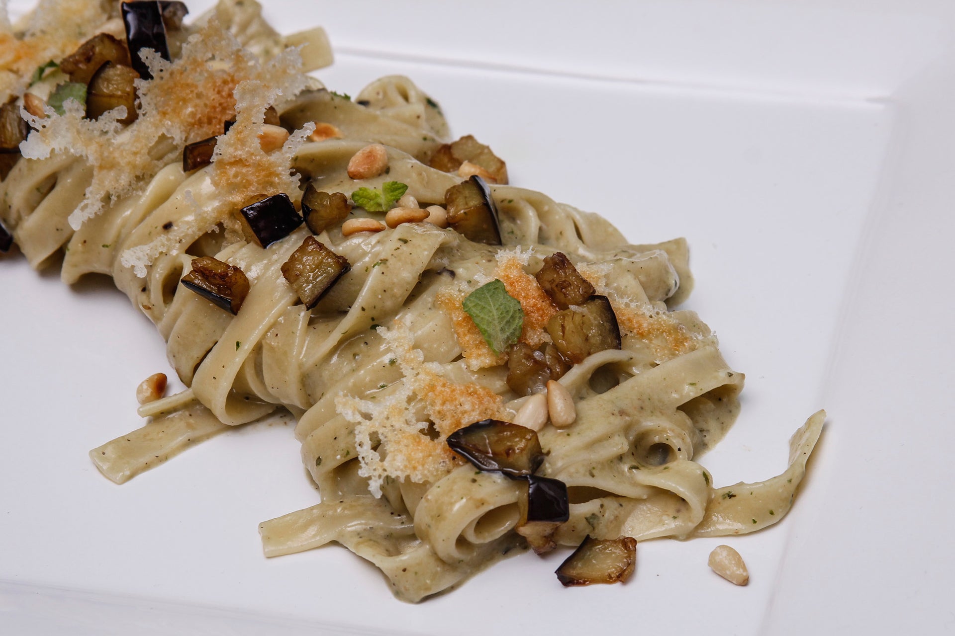 Tagliatelle with eggplant pesto, crunchy caciocavallo cheese, fresh mint, toasted pine nuts and diced eggplant