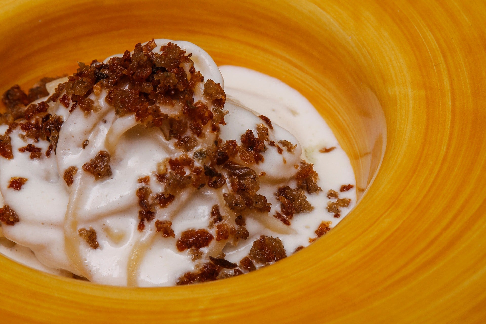 Spaghetti with creamy cauliflower, provolone cheese, crispy bread with anchovies and capers 