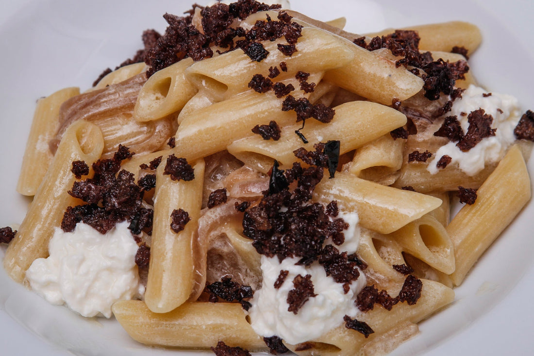 Penne alla cipolla rossa con stracciatella di burrata pugliese e croccante alle olive nere