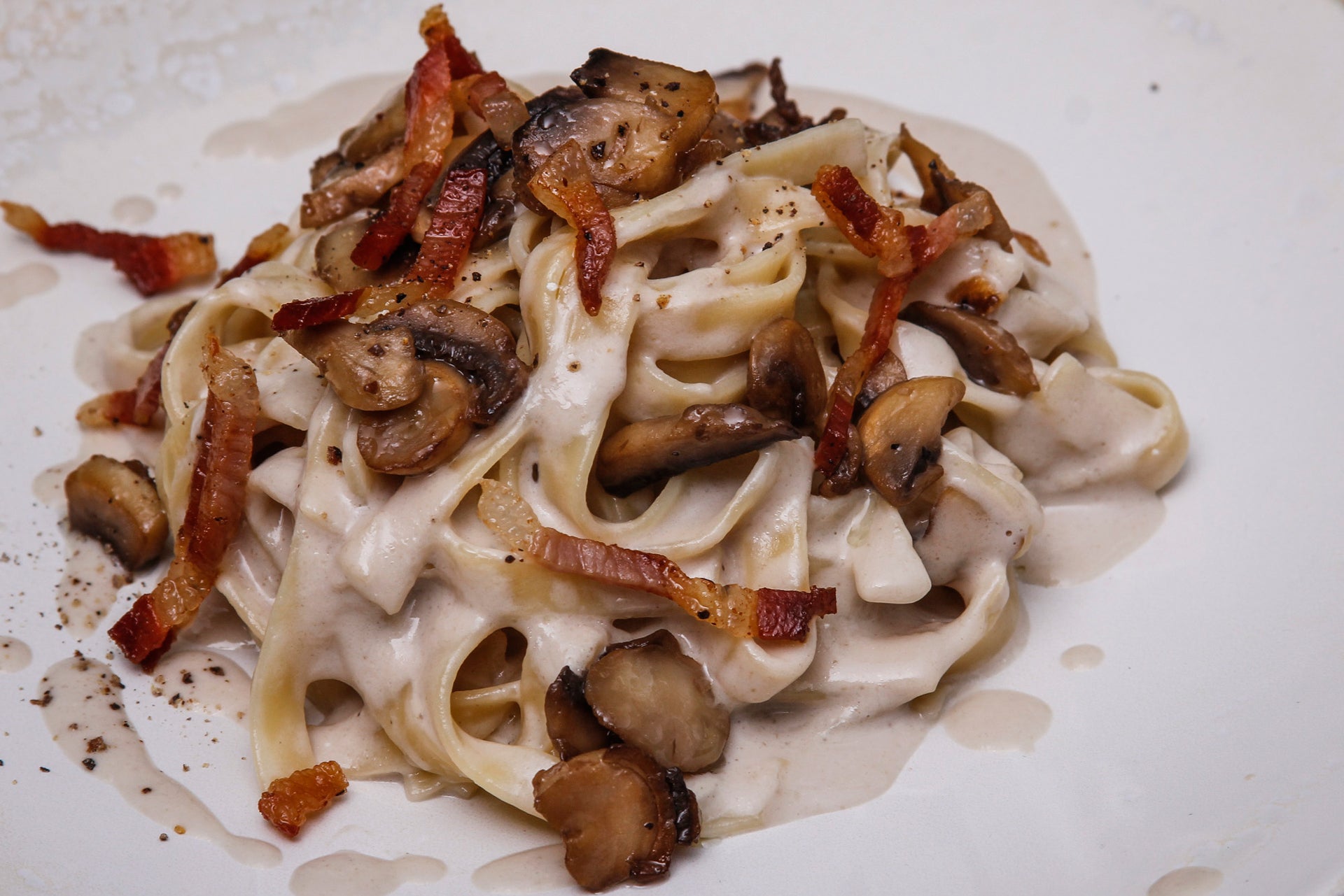 Tagliatelle with mushrooms, a mushroom parmesan sauce, and crispy bacon. 
